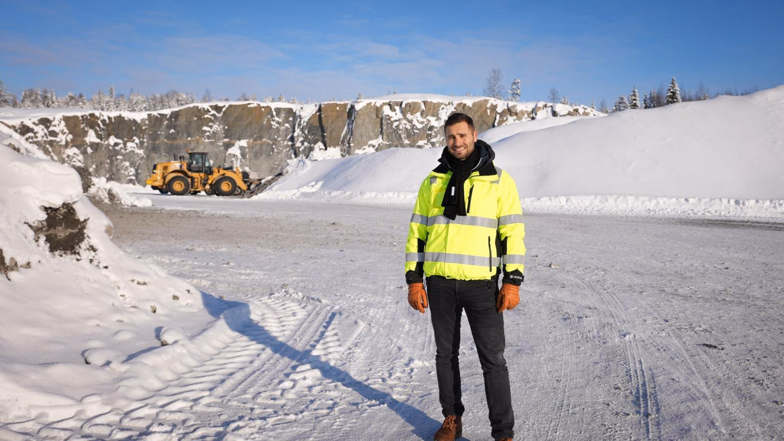 Worker standing in a sunny winter landscape