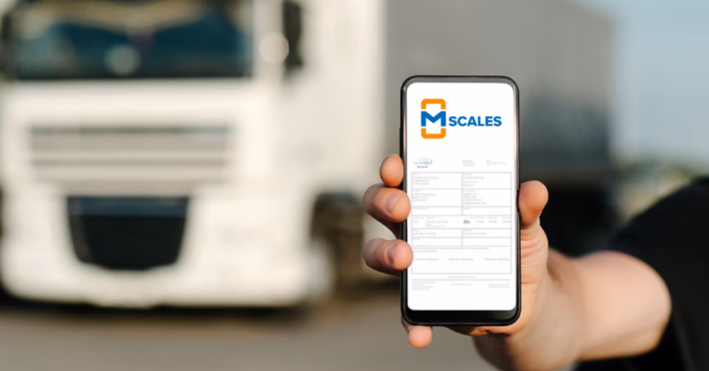 Hand holding a smartphone displaying the mScales interface with a blurred truck in the background