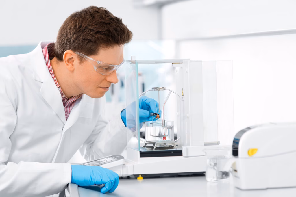 Muž provádí přesné vážení pomocí laboratorní váhy