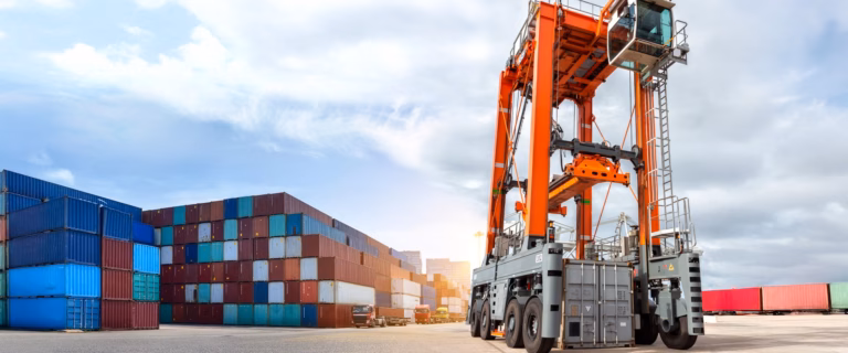 Large orange straddle carrier at a shipping container terminal