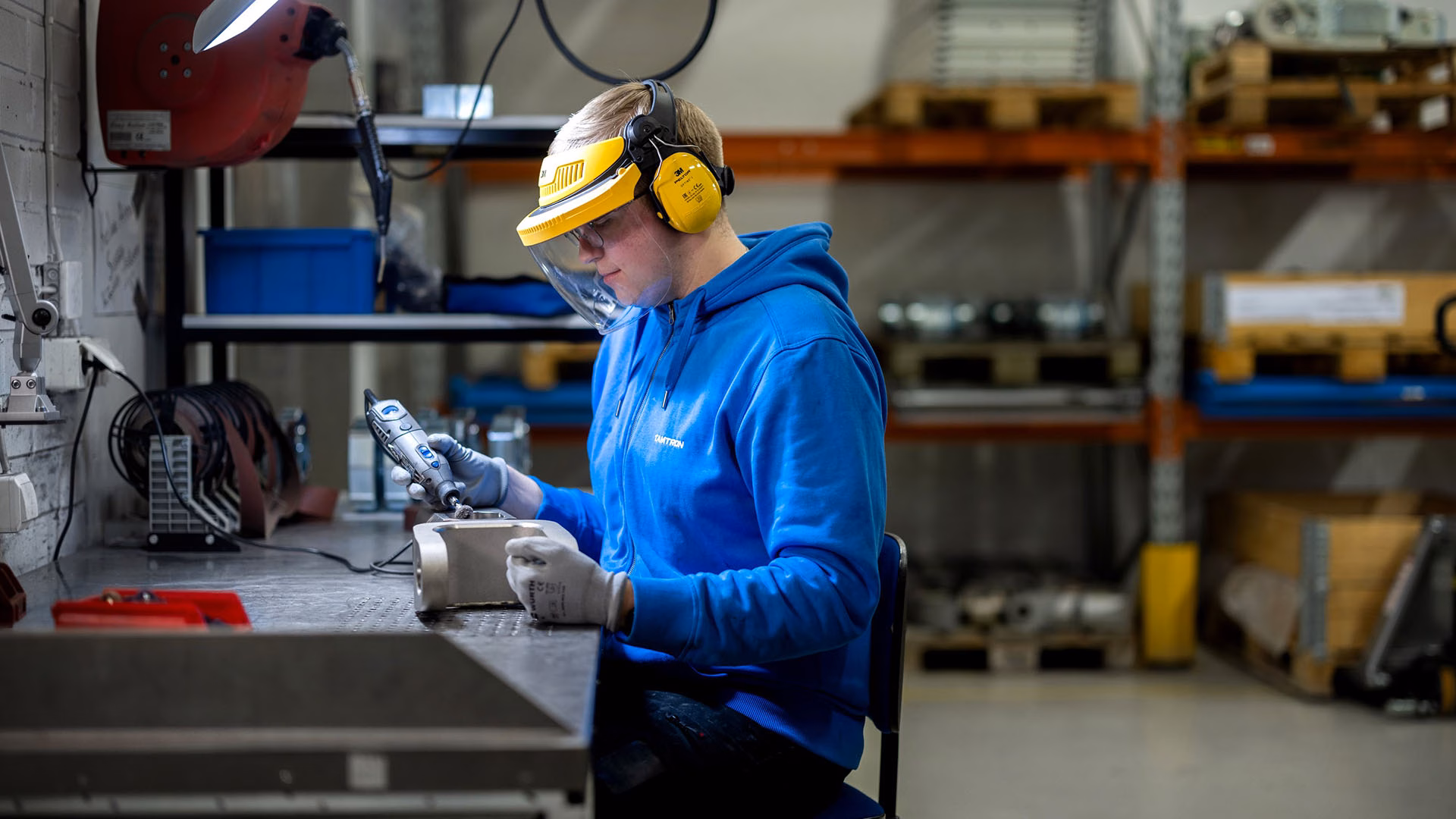 Tamtron-medarbejder der arbejder med en vejekomponent ved en arbejdsbænk