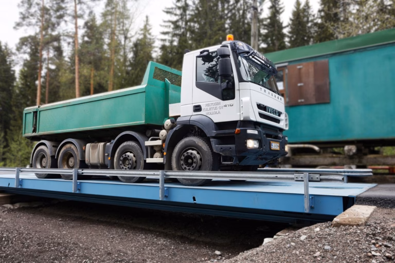 Truck on a transportable steel scale with a forest in the background