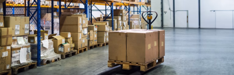 Pallet truck transporting boxed goods in a warehouse